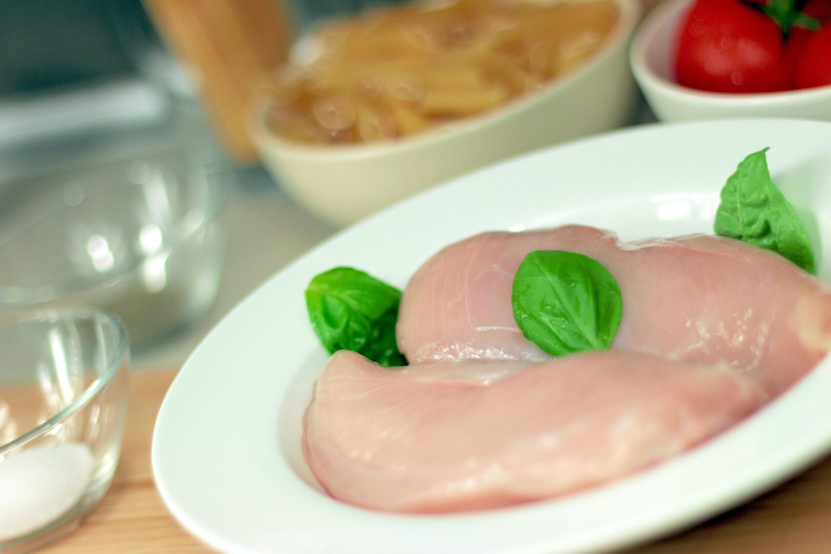 A plate of food with meat and basil leaves.